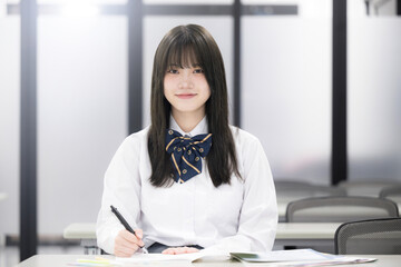 学校や塾の授業中に勉強する女子高校生 カメラ目線
