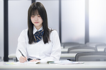 学校や塾の授業中に勉強する女子高校生 カメラ目線