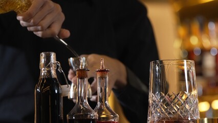 Closeup hand bartender holding jigger to measure liquor sugar into mixing glass ingredients alcohol...
