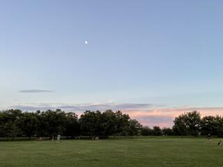 Fototapeta premium Moon Rising Above an Open Field at Sunset