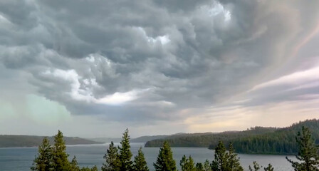 Obraz premium Storm Clouds Over Treeline and Lake Coeur D'Alene