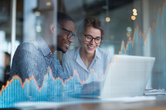 Business colleagues analyzing financial business graphs on laptop