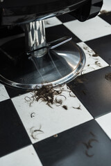 Fresh haircut leaves stylish remnants on checkerboard salon floor