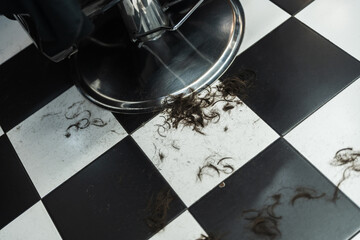 Barber shop floor covered in freshly cut hair from recent grooming session