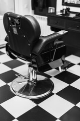 Classic barber chair in a stylish black and white tiled salon interior