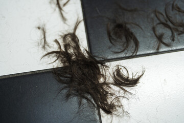 Hair clippings scattered on a contrasting floor after a fresh haircut