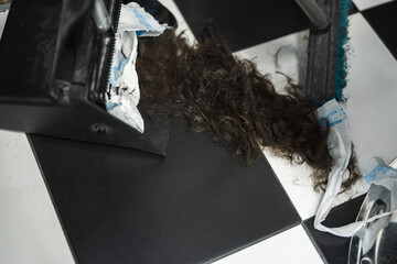 Hair clippings gathered at a barbershop during a busy salon day
