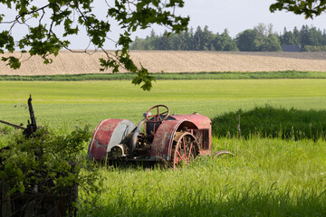 Back view of vintage agricultural tractor abandoned in a farmer's field in southern Ontario Canada