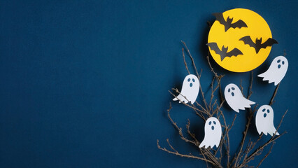 Halloween background with flying bats, white ghosts, yellow moon, and bare tree branches on dark blue backdrop, ideal for spooky party invites, seasonal promotions, or festive designs
