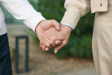 Lovely senior couple walking together outdoors, closeup