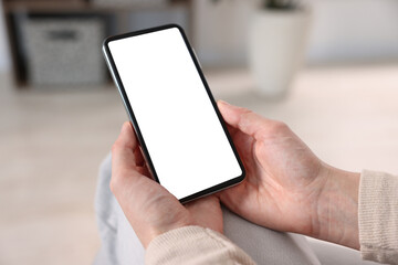 Woman using modern smartphone at home, closeup