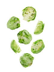 Fresh ripe cabbages falling on white background