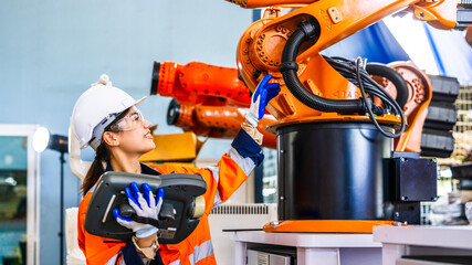 Asian development technician engineer testing artificial intelligence robot arm at high technology research manufactue with equipment. Factory worker, asian woman working with adept robotic arm. © unikyluckk