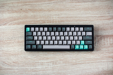 Gray and Teal Keyboard on Light Wood Desk