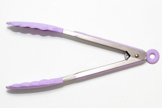 A pair of kitchen tongs with purple silicone tips and stainless steel handles, resting on a clean white surface.