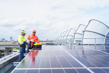 Electrical engineers are inspecting and installing a solar panels on the building rooftop.