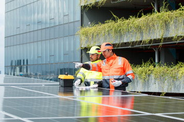 Electrical engineers are inspecting and installing a solar panels on the building rooftop.