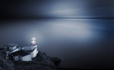 A Serene Lighthouse is Standing Beautifully by the Tranquil Sea during Twilight