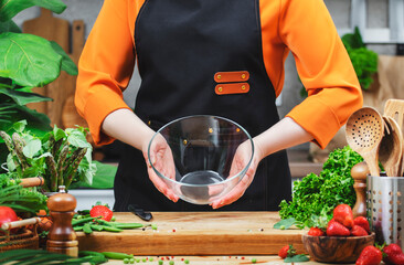 chef in an orange shirt prepares to blend fresh vegetables while surrounded by an array of colorful...