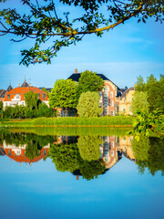 Sankt Jørgens Sø in Copenhagen, Denmark, reflects historic buildings and lush greenery in calm...
