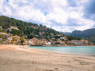 Soller Playa Beach in Mallorca, Spain, features turquoise waters, sandy shores, and hillside...