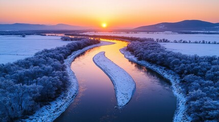 Winter sunrise over a winding river.  Panoramic view of a frozen landscape with a river snaking through snowy fields and frosted trees.  Sunrise paints the sky in vibrant hues of orange and pink