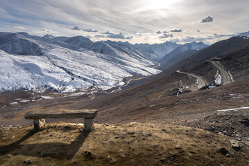 Solitary Stone Bench Overlooking Serene Mountain Pass