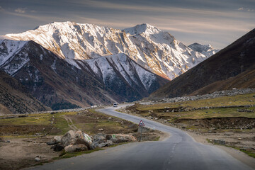 Curving Road Leading to Snow-Capped Mountain Range