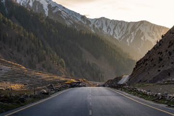 Mountain Road Leading into Forested Valley at Sunset