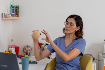 Pediatrician using knitted ball for explanation during online consultation