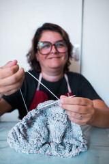 Happy woman knitting a jumper