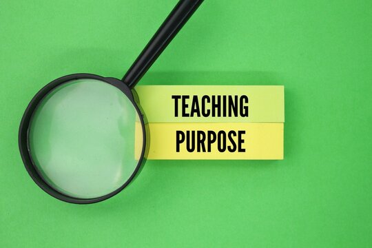 A magnifying glass and colored paper with the words teaching purpose. extends beyond simply transmitting knowledge. It encompasses fostering a love of learning, developing critical thinking skills