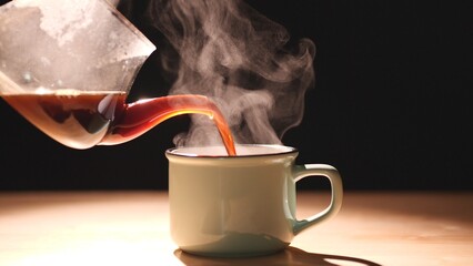 Coffee. Close up pouring black coffee into green ceramic cup, mug with beautiful steam smoke spins,...