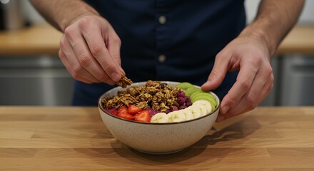 Hands Topping a Vibrant Healthy Fruit and Granola Smoothie Bowl in a Modern Kitchen for a Nutritious Breakfast