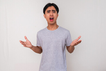 Portrait of an angry young Asian man looking at the camera with a serious expression, isolated on...