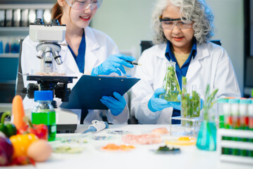 Team of scientists examining food samples in a lab with microscopes. Perfect for themes of food...