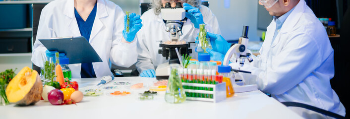 Team of scientists examining food samples in a lab with microscopes. Perfect for themes of food science, biotechnology,