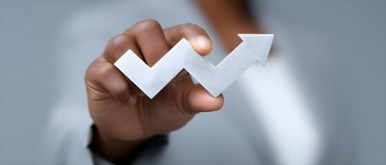 Business professional holding upward growth arrow symbol