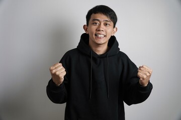 Excited Asian Man Celebrating with Fists Raised