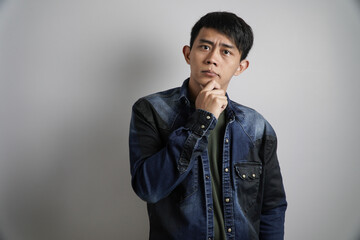 Thoughtful Asian Man with Hand on Chin