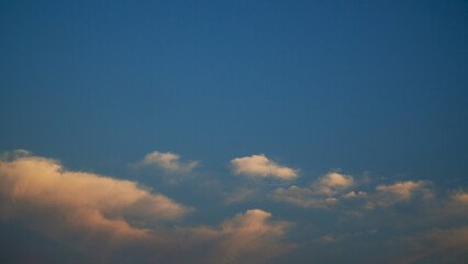Softly Lit Clouds Drifting in a Serene Blue Sky at Dusk
