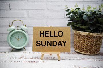 Hello Sunday text message with easel stand on wooden background