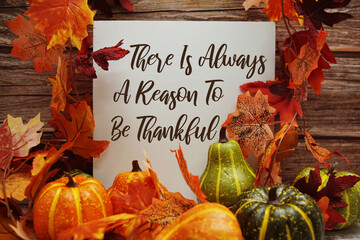 There Is Always A Reason To Be Thankful text with maple leaf decoration on wooden background