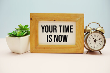 Your Time Is Now text with alarm clock on blue and pink background