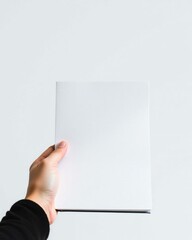 Hand holding blank white square booklet mockup
