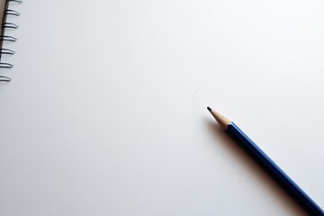 Empty white sheet of paper with a ened pencil lying diagonally on the surface for drawing or writing ideas and creative work