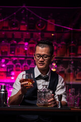 Bartender is pouring whiskey into a glass a customer's glass.