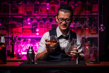 Bartender is pouring whiskey into a glass a customer's glass.	
