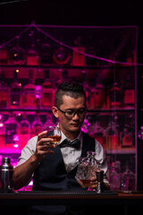Bartender is pouring whiskey into a glass a customer's glass.