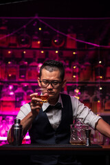 Bartender is pouring whiskey into a glass a customer's glass.